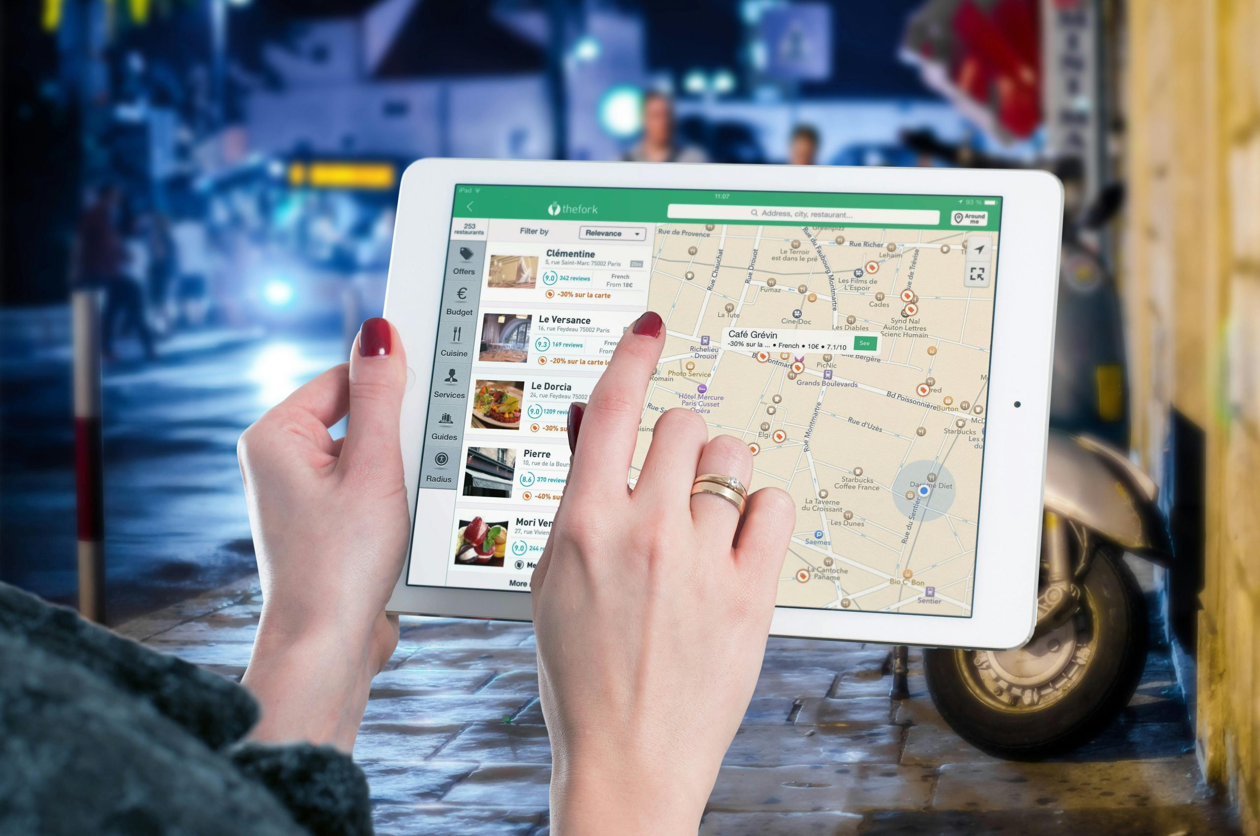 Best Company of Immigration Consultants Near Me Hands using a digital map on a tablet in an urban setting at night, illustrating navigation and technology.